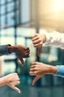 © JordaanExams/peopleimages.com - Business people, thumbs down and no with sign for negative review, feedback or disapproval at office. Closeup of group, employees or team with hand or emoji for bad news, fail or mistake at workplace