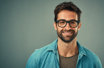 Portrait, man and glasses in studio for prescription, vision and confidence with pride for clear eyesight. Product, eyewear frame and male person with spectacle for strain, care and gray background