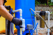 © ungvar - An artesian well system pump house is being connected to PVC water pipe