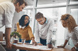 © BestLens/peopleimages.com - Explaining, group and planning with paperwork in office, creative and brainstorming of interior designer. Collaboration, employees and reading of ideas, pointing and people in meeting for project