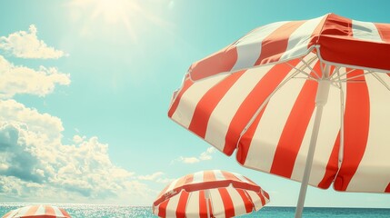 Wall Mural - Red and White Striped Beach Umbrellas Under Sunny Blue Sky at Seaside