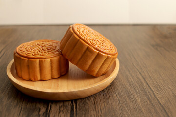 Mooncake on a wooden plate, tradition chinese mooncake on wood table. Mid Autumn celebration, Happy Chinese translation Mid Autumn festival.