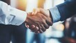 © Hailie - Diverse handshake in warm light signaling agreement.