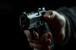 © Dzmitry - A Male Hand Firmly Grasping A Gun Against A Dark Black Background Expressing Intensity And Tension