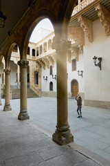 Tourist girl visiting and taking photos in the courtyard of the Salina or Fonseca Palace, from the 16th century, in the city of Salamanca, in Castilla y Leon, Spain. Public and free access without tic