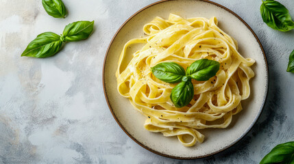 A delicious plate of creamy fettucini served with fresh basil on table