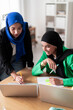 © Studio Marmellata - Two women in hijabs work together on their laptops in a bright, modern office. Their expressions show focus and collaboration in a professional environment.