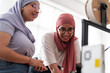 © Studio Marmellata - Two women in hijabs smile as they collaborate on a 3D printing project, demonstrating teamwork and a positive working environment. They are engaged in a discussion about the project.