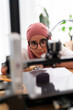 © Studio Marmellata - A woman in a dark red hijab closely adjusts the settings of a 3D printer, demonstrating precision and expertise in handling advanced technology and equipment.