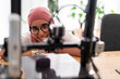 © Studio Marmellata - A woman in a dark red hijab smiles as she looks at the outcome of a 3D printing project. Her expression shows satisfaction and joy in the successful completion of the task.