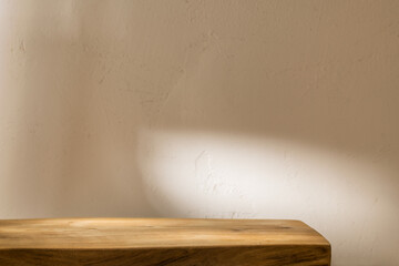 Empty table on stucco background with natural shadow on the wall. Stylish background for branding products, presentation, food and health care.	
