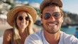 © Lens Legacy - A cheerful couple wearing hats and sunglasses, smiling brightly while posing for a selfie at the beach, epitomizing a delightful and sunny seaside vacation.