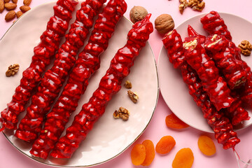 Wall Mural - Plates with tasty churchkhela on pink background