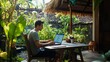 © The Little Hut - Young digital nomad working remotely on his laptop in Bali Freelancer Man in workation video call Travel and remote online work Outdoor in the garden desk for  remote workers someone a : Generative AI