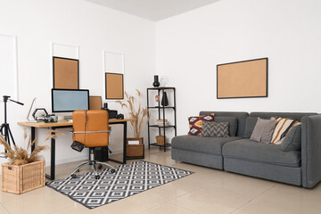 Wall Mural - Stylish workplace with modern computer, and photographer's equipment and sofa near white wall in light office