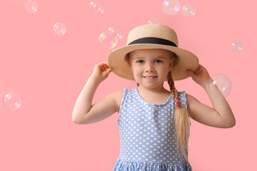 Canvas Print - Happy little girl in hat with soap bubbles on pink background