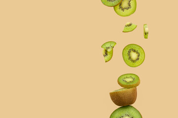 Wall Mural - Pieces of fresh kiwi flying against color background