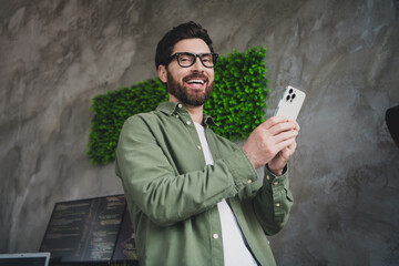 Sticker - Photo of professional it specialist young man hold smart phone loft interior office indoors