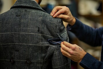 Close-up of a tailor sewing a jacket.