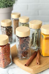 Wall Mural - Different spices in glass jars on white marble table