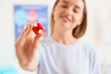 Sticker - Young woman with thyroid gland model at endocrinologist's office, closeup