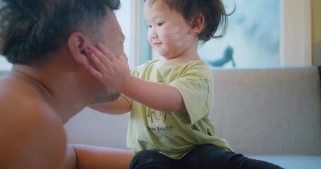 Poster - A tender moment between an Asian father and his daughter, she smile lovingly touches his face while playfully applying white powder on both of their faces, bond and affection family love connection