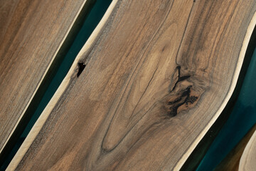 Expensive vintage furniture. The table is covered with epoxy resin and varnished. Luxury quality wood processing. Wooden table on a dark background. A blue epoxy river in a round tree slab.