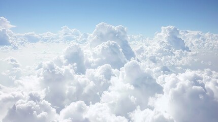 Wall Mural -   Blue sky in background, clouds in foreground viewed from airplane window