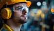 © CHONCHANOK PHOTO - A focused construction worker in safety gear, highlighting the importance of safety in industrial environments.