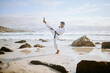 © peopleimages.com - Karate beach and man with kick for training, practice and learning aikido, taekwondo and jiujitsu. Sports, nature and person by ocean for fitness, exercise and workout for martial arts competition