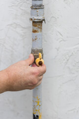 Wall Mural - A man is holding a pipe wrench and is about to turn a valve