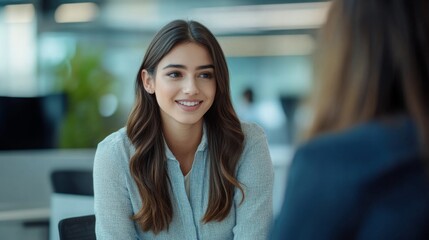 Poster - A businesswoman in a casual conversation with a colleague, both smiling and engaged, with office cubicles in the background.
