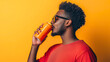 © Stefan - Side profile of African American man drinking fresh, cold drink, tasty beverage, soda carbonated liquid from blank metal or tin can with mockup isolated on background with empty copy space refreshment