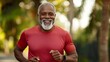 © anantachat - An elderly black man jogging in a park with a joyful expression showcasing an active and healthy lifestyle in later years Stock Photo with copy space