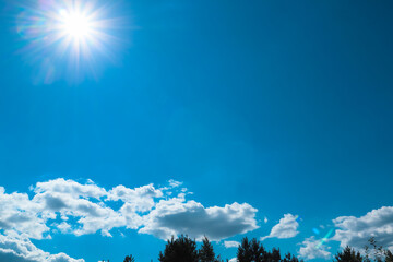 Sunny day. Blue sky with white clouds and sun. Sunburst With Lens Flare. Heavens with bright weather, summer season outdoor