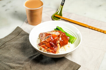 Roasted Goose with Rice with milk kopi chopsticks and spoon served in bowl isolated on napkin side view of hong kong food on marble background