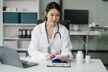 Wall Mural - Doctor working on laptop computer and tablet and medical stethoscope on clipboard on desk, electronics medical record system EMRs concept.