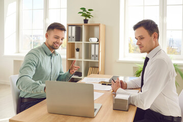 Male happy business partners working at desk, businessmen busy at laptop commercial operation or company. Friends small business marketing plan, share interests, investments in enterprise or activity