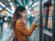 © Mikki Orso - Young woman using automated machine for ticket purchase at transportation station