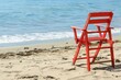© kinara art design - Red Lifeguard Chair on a Sandy Beach Facing the Ocean