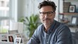 © Beauver - Portrait of a middle-aged man wearing glasses, smiling confidently in a bright home office environment, conveying a relaxed and professional vibe.