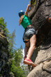 © MIKE FOUQUE - Young girl climbing a rock