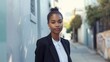 © Anna - Confident young woman in a black blazer standing on a quiet urban street. Concepts of professionalism, confidence, and urban lifestyle.