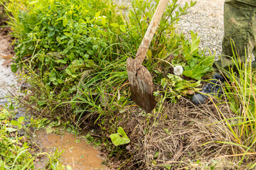 Man digs drainage ditch with shovel. Water in the drainage ditch