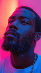 Wall Mural - Close-up of man in neon lights with thoughtful expression