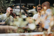 © qunica.com - Startup team engaging in a business meeting outdoors, discussing, brainstorming, and analyzing strategies in a relaxed atmosphere.