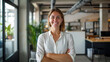 © stock1 - Portrait of a smiling female Australian startup founder in their 30s standing in a modern office interior