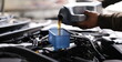 © H_Ko - Hands pouring machine oil through a funnel into a car engine, close-up. Oil change, lubrication of motor parts