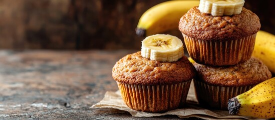 Poster - Homemade banana muffins are stacked on a brown background A healthy vegan dessert Close up with selective focus Horizontal composition. with copy space image. Place for adding text or design