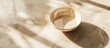 © vxnaghiyev - Beige bowl filled with water on a white marble table seen from above Room for text. with copy space image. Place for adding text or design